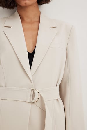 Blazer med vida axlar och bälte med D-ring