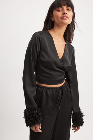 Omslagsbluse i sateng med fjærdetaljer