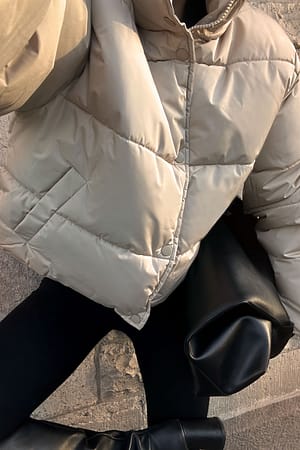 Kort vatteret jakke i genanvendt materiale og med trykknap