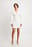 Asymmetrische mini-jurk met lange mouwen en knopen