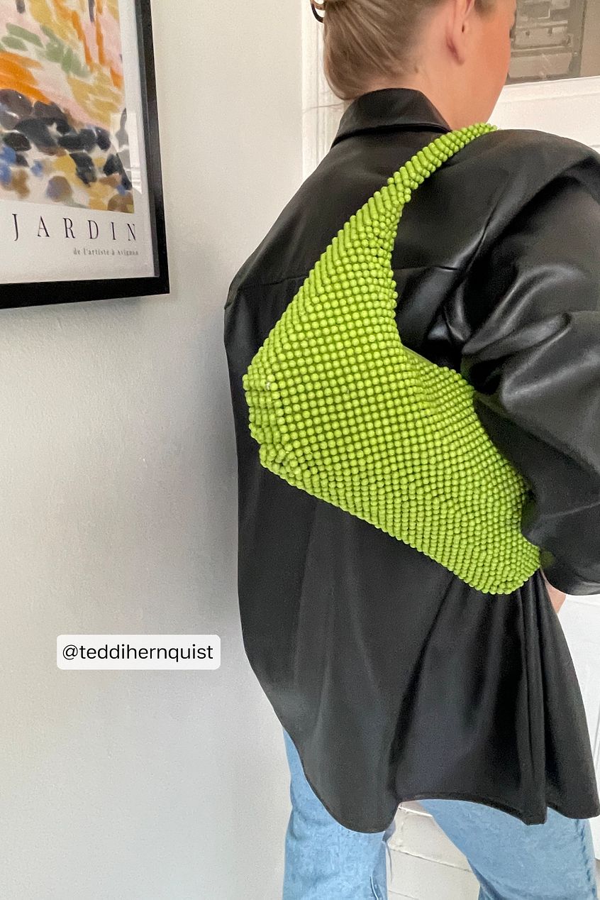 Na-Kd Beaded shoulder bag in chartreuse green with a squared-off rounded hobo design. The shoulder bag is beaded all over and has a zipper closure.