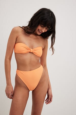 Orange Bandeaumallinen bikiniyläosa suurella solmulla