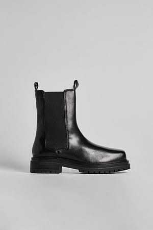 Black Kraftige boots i skinn med flat såle