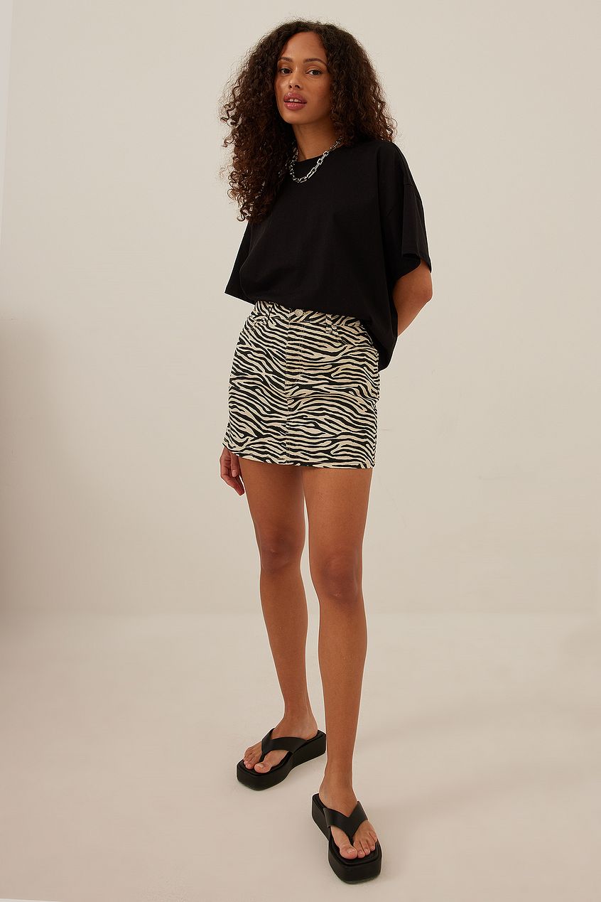 NA-KD zebra printed denim mini skirt with a five-pocket design, a mini length and a patterned material in denim.