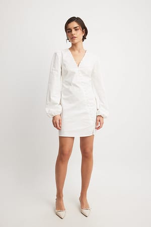 White Asymmetrische mini-jurk met lange mouwen en knopen